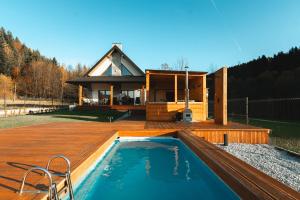 a house with a swimming pool on a wooden deck at Muciówka in Jurków