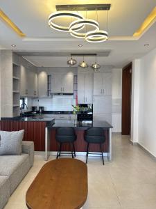 een keuken en woonkamer met een tafel en een bank bij Residence Gratia by Eagle View in Kigali