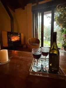 een fles wijn en twee glazen op een tafel bij Casagiardino Sofía in Marina di Varcaturo +24 foto's