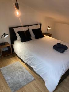 a bedroom with a large white bed with black pillows at Oniris - Parenthèse urbaine in Mont-de-Marsan