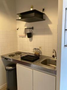 a small kitchen with a sink and a stove at Oniris - Parenthèse urbaine in Mont-de-Marsan