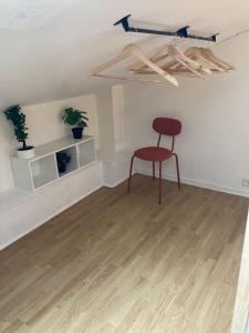 a red chair sitting in a room with a table at Oniris - Parenthèse urbaine in Mont-de-Marsan