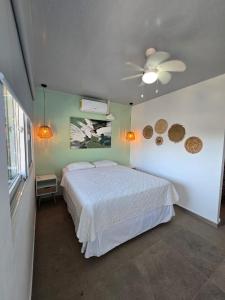 a bedroom with a bed and a ceiling fan at Hotel Zelen in Tamanique