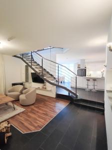a living room with a staircase in a house at das Alpenblick & Outdoor Lodge Nauders in Nauders