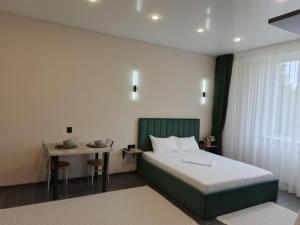 a bedroom with a bed and a small table at Berloga Hotel in Pavlodar