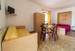 a room with two beds and a table with chairs at Baia Azzurra in Capoliveri