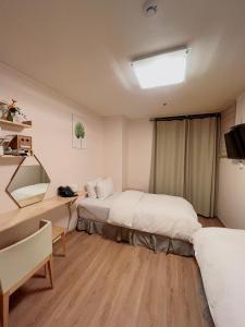a room with two beds and a desk and a desk at Whouse-sinchon in Seoul