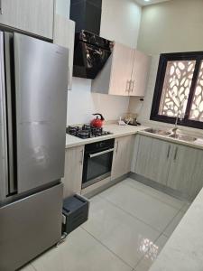 a kitchen with a stainless steel refrigerator and a sink at Sunset Senegal in Rufisque