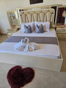 a bed with a heart and a robe on it at Sunset Senegal in Rufisque