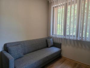 a couch sitting in a room with a window at Хотел Ресторант Ваката in Teteven