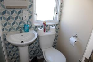 a small bathroom with a toilet and a sink at Clearsands at Haven in Mablethorpe +4 photos