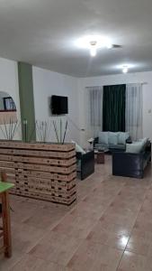 un ampio soggiorno con divani e televisione di Cómodo y acogedor departamento familiar, cerca del casco histórico a Gualaceo