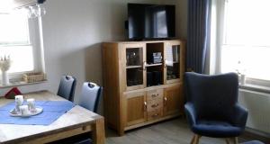 a dining room with a table and a tv on a cabinet at Ferienwohnung Hunold in Marsberg