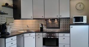 a kitchen with white cabinets and a clock on the wall at Ferienwohnung Hunold in Marsberg