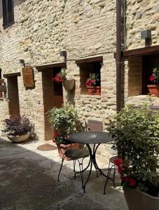 a table and chairs in front of a stone building at Le Dimore dei Ritaldi in Castel Ritaldi