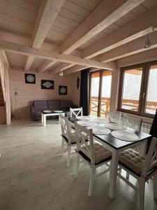 a dining room with a table and chairs and a couch at Domek Hulanka in Szczyrk