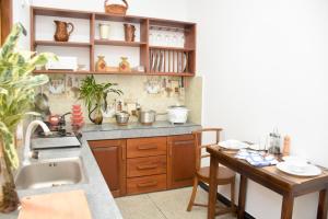 a kitchen with a sink and a counter with a table at The White Crane Koggala in Habaraduwa Central