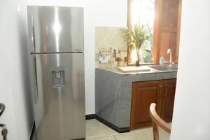 a stainless steel refrigerator in a kitchen with a counter at The White Crane Koggala in Habaraduwa Central