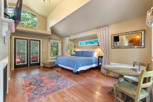 een slaapkamer met een bed, een bureau en ramen bij The Grand Treehouse Resort in Eureka Springs