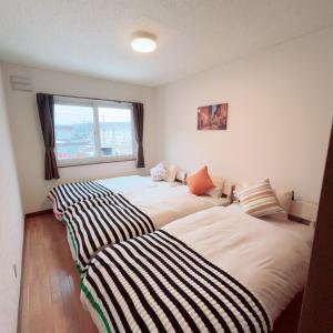 twee bedden naast elkaar in een kamer bij Transys three in Chitose