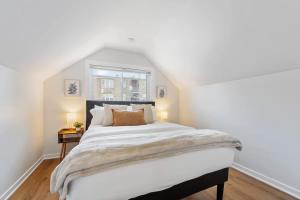 a bedroom with a large white bed and a window at New 10-min to Downtown in Oak Park