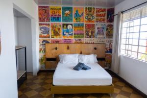 a bedroom with a bed with two blue shoes on it at La Palmera Hostel in Cali
