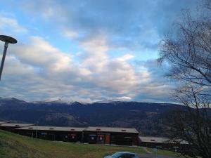a building on a hill with mountains in the background at Ty-Bougnat in Murat-le-Quaire +14 photos