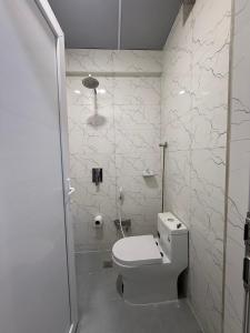 a white bathroom with a toilet and a shower at فندق حمورابي Hammurabi Hotel in An Nāşirīyah +33 photos
