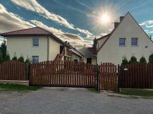 a wooden fence in front of a white house at Dom Gościnny Ania in Wisełka