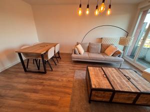 a living room with a couch and a table at L'appartement du Château in Pfastatt