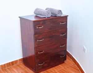 a wooden dresser with two towels on top of it at Tropical lodge in Kakamega