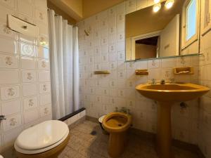 a bathroom with a toilet and a sink at Hotel Siena Pinamar in Pinamar +17 photos