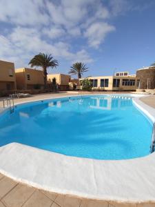 una grande piscina blu con palme e edifici di Ventana Azul a Costa Calma