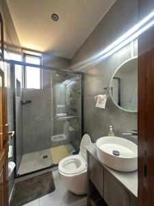 een badkamer met een toilet, een wastafel en een douche bij Residence Gratia by Eagle View in Kigali