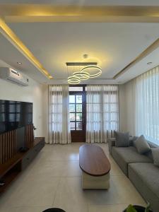 een woonkamer met een bank en een tv bij Residence Gratia by Eagle View in Kigali +18 foto's
