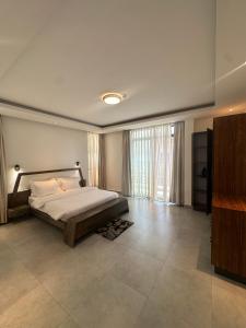 a bedroom with a bed and a large window at Residence Gratia by Eagle View in Kigali +49 photos