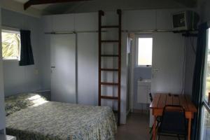Un pat sau paturi într-o cameră la Pukenui Holiday Park