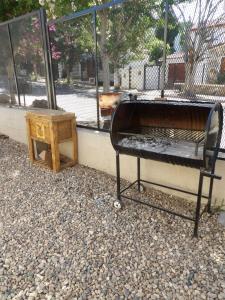 een bed en een bijzettafel naast een hek bij Nova Hotel Boutique in Villa Carlos Paz