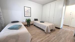 due letti in una stanza con pareti bianche e pavimenti in legno di Villa Ruths Stay Polle a Kouvola