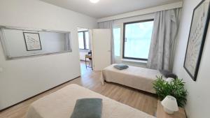 una piccola stanza con due letti e una finestra di Villa Ruths Stay Polle a Kouvola