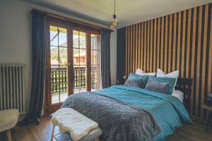 una camera da letto con un letto blu e un balcone di Appartement cocooning à Charmey a Charmey