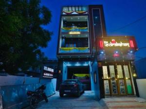 een auto die 's nachts voor een gebouw geparkeerd staat bij Hotel Airport Fly Inn in Lucknow