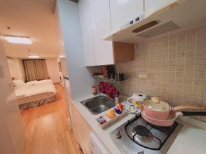 a small kitchen with a stove and a sink at Whouse-sinchon in Seoul