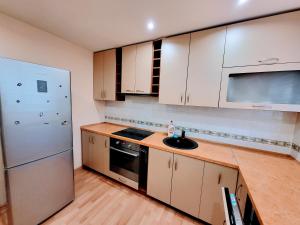 una cucina con mobili bianchi e un lavandino di SPACIOUS Apartment in the SUN CITY a Šiauliai