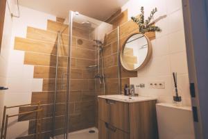 un bagno con doccia, lavandino e specchio di Appartement cocooning à Charmey a Charmey