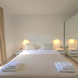 a bedroom with a large white bed with two towels on it at 3-bedroom Sea View Home with Private Parking in Mokošica