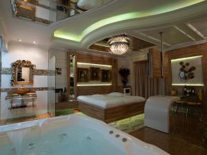a bathroom with a tub and a bed in a room at Golden Motel Diária suítes amplas, conforto premium e total privacidade in Passo Fundo