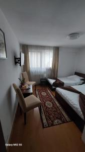 a hotel room with two beds and a chair at CASA RYANA SINAIA in Sinaia