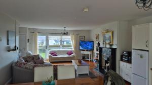 a living room with a couch and a tv at Fairway Haven in Dunfanaghy