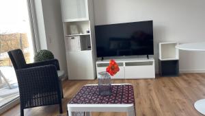 a living room with a television and a vase on a table at Villa LaLeo in Künzelsau